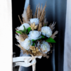 white artificial bouquet with roses, carnations, Phalaris, and coarse grass wrapped in satin