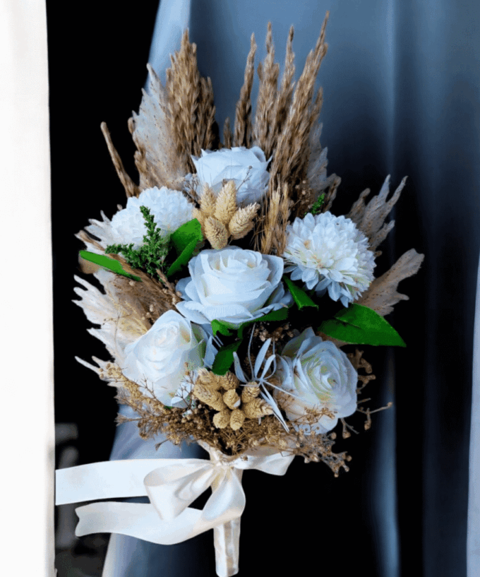 white artificial bouquet with roses, carnations, Phalaris, and coarse grass wrapped in satin